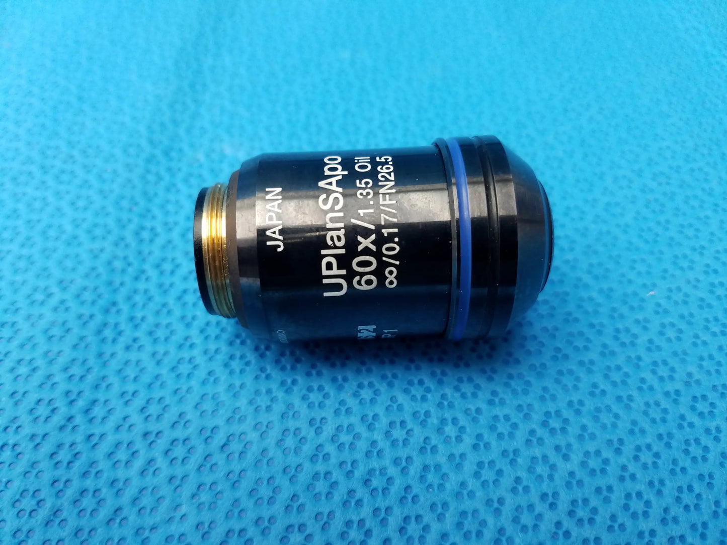 Black Olympus UPlanSApo microscope objective lens with 60x magnification, gold threading, blue ring, numerical aperture 1.35, field number 26.5