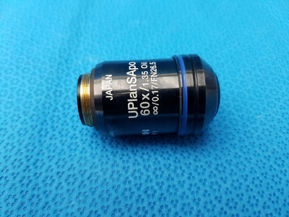 Black Olympus UPlanSApo microscope objective lens with 60x magnification, gold threading, blue ring, numerical aperture 1.35, field number 26.5