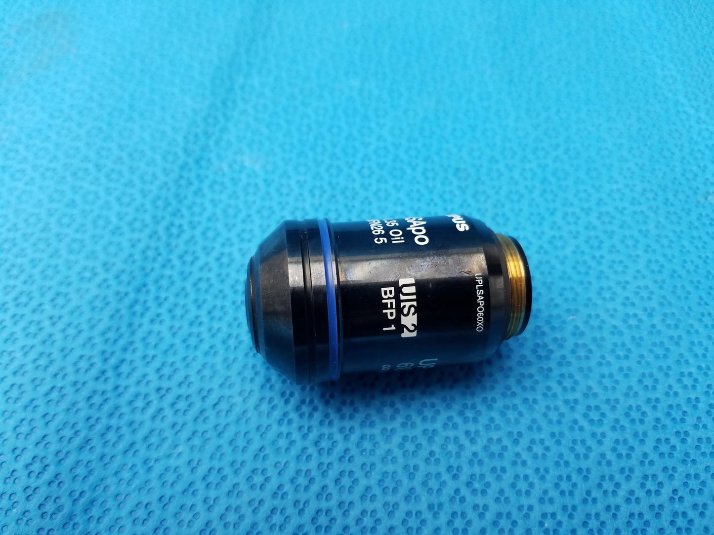 Black Olympus UPlanSApo 60x microscope objective with numerical aperture 1.35 and gold threaded mount with field number 26.5