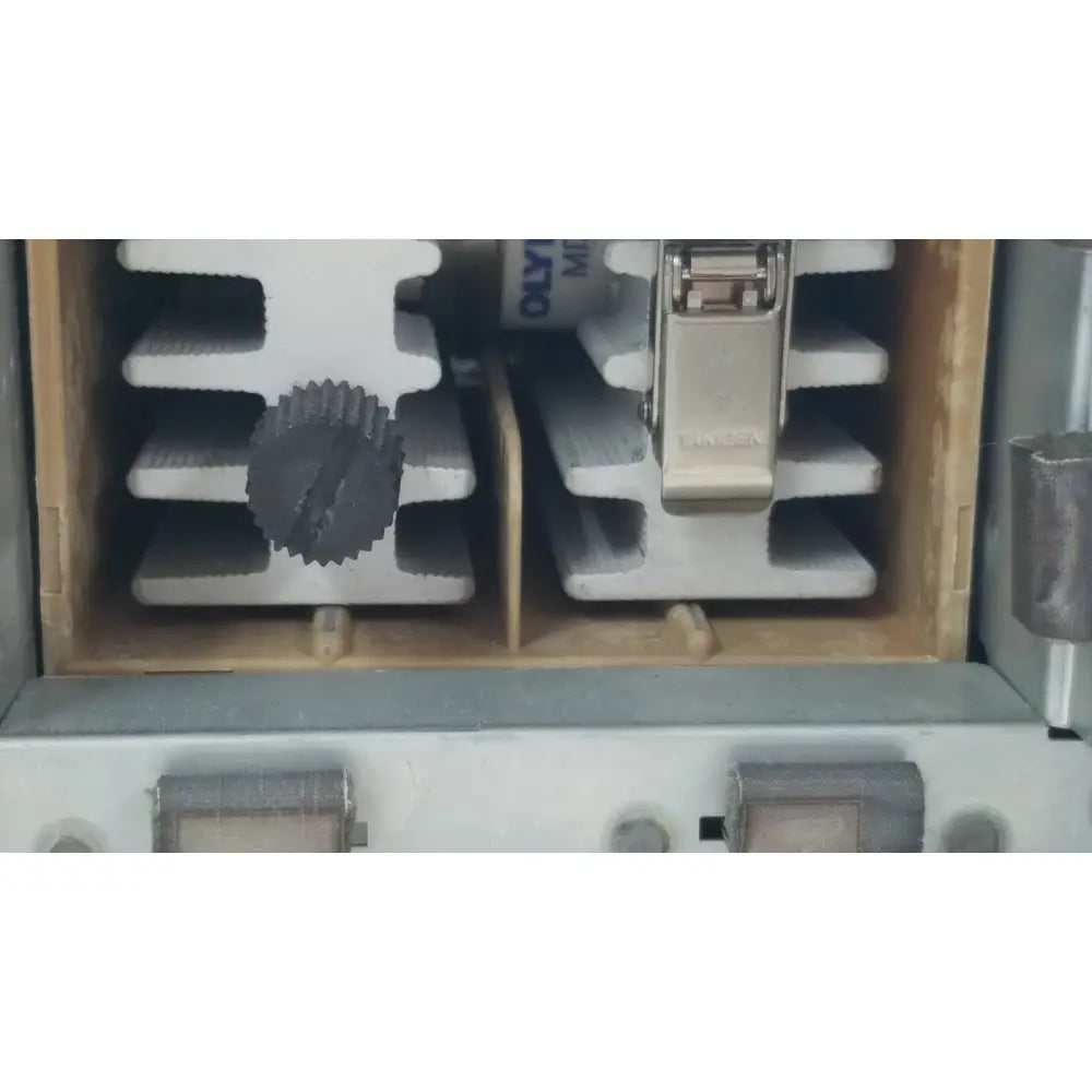 Silver-colored metal clamp with a textured dark gray gear-like knob on the olympus visera clv-s40 emergency lamp
