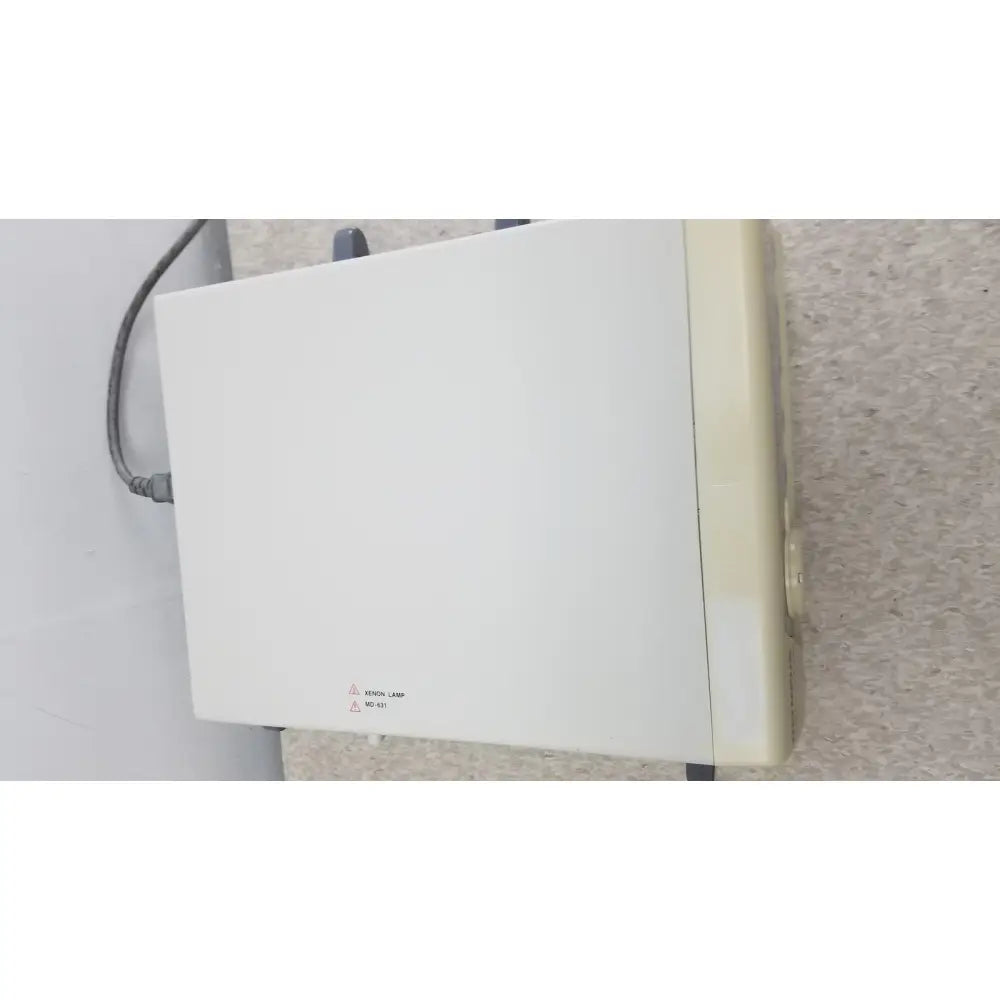 White rectangular olympus visera clv-s40 emergency lamp with beige side panel and gray power cord attached