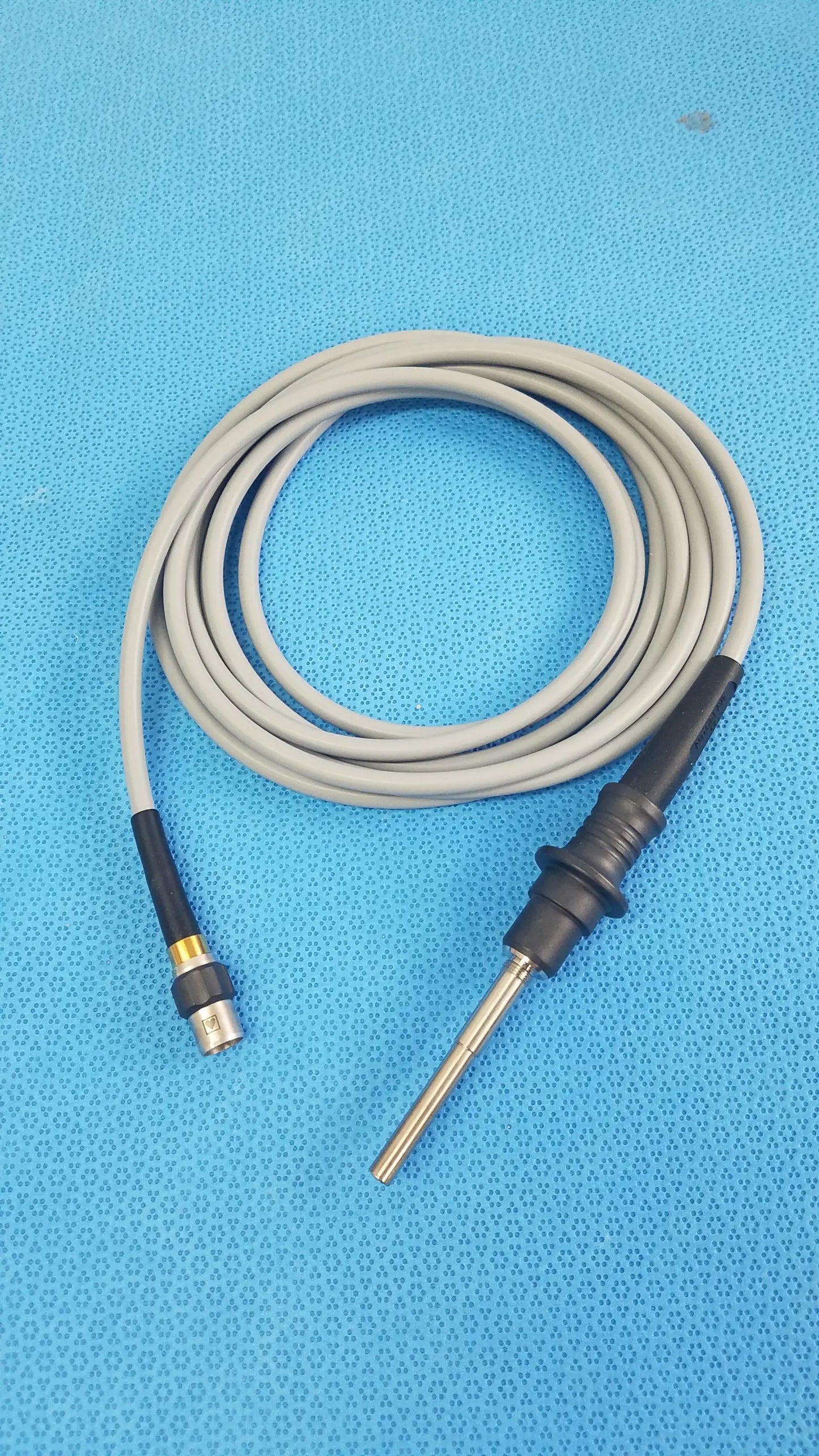 Gray coiled fiber optic light cable with black connectors and metallic probe tip for reuse medical equipment olympus wa03200a