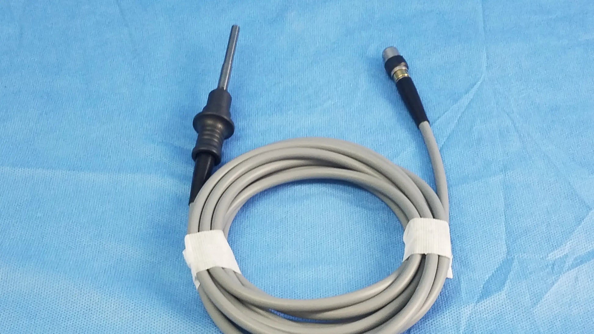 Gray coiled fiber optic light cable with black and metallic connectors for medical use olympus wa03200a s model