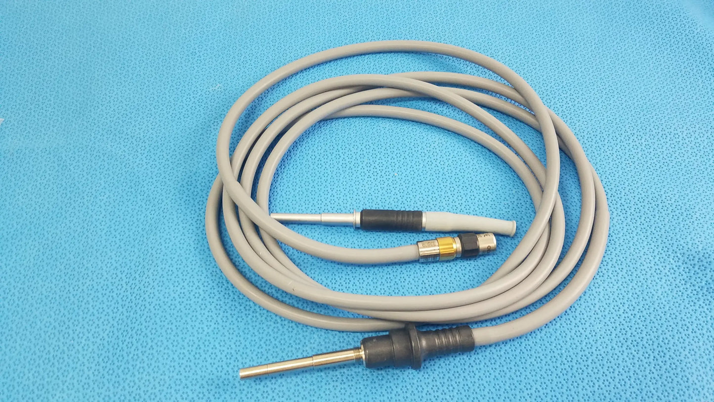 Gray coiled medical equipment cable with black and metallic connectors for olympus wa03300a light guide use