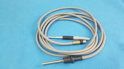 Gray coiled medical equipment cable with black and metallic connectors for olympus wa03300a light guide use