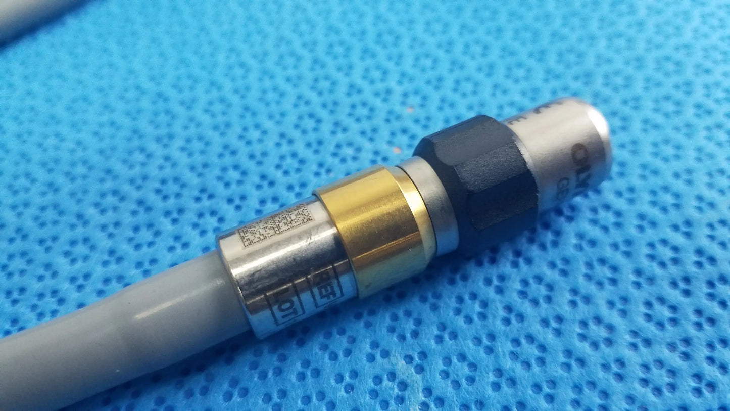 Gray cable with metallic brass and black connector for olympus wa03300a light guide used in medical equipment