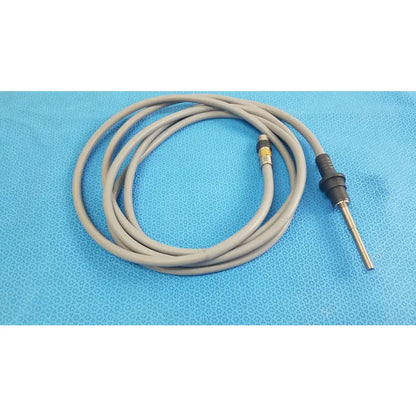Gray coiled medical equipment cable with black metallic connector for olympus wa03300a light guide use