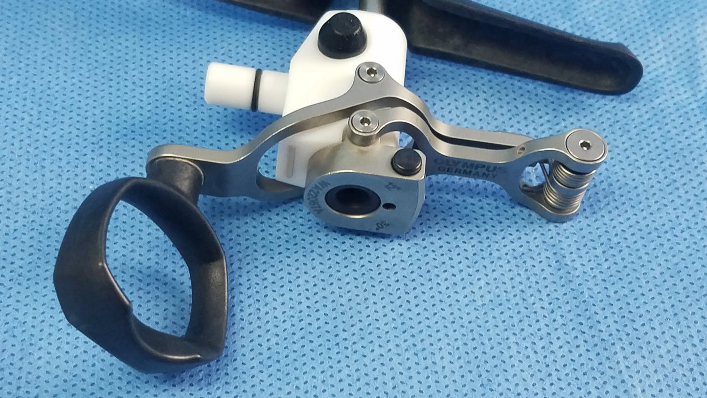 Silver surgical working element with black rubber handles and white plastic component engraved with olympus branding