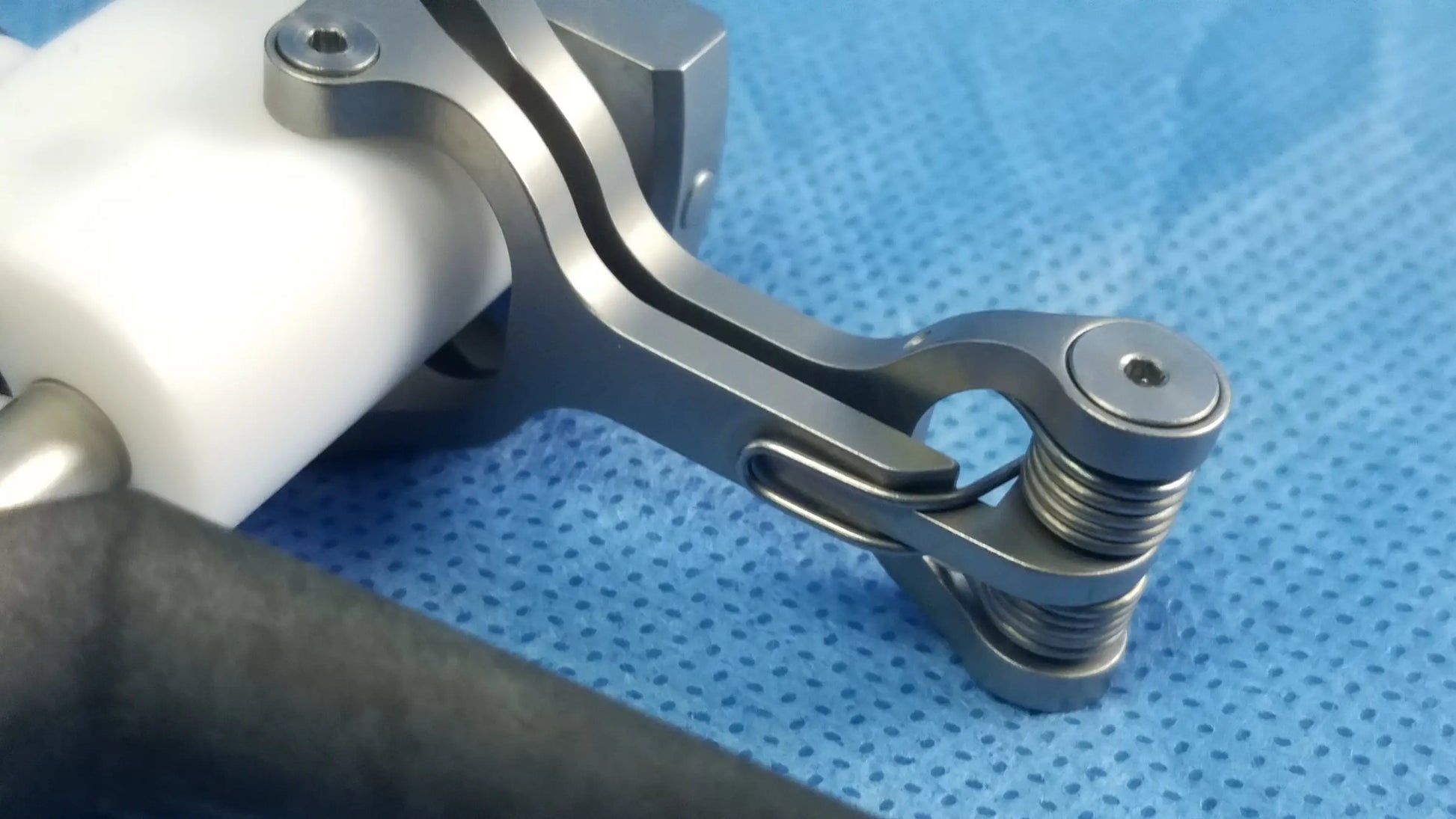 Silver-toned Olympus WA22067A passive monopolar working element with coiled spring mechanism and metallic joints surgical instrument