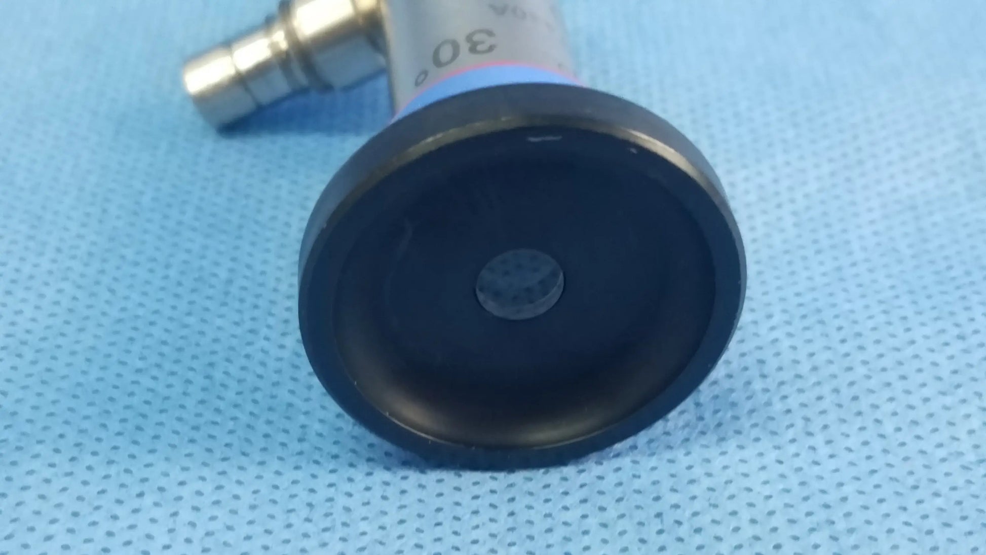 Black circular end cap with metallic connector and labeled tubing of olympus wa2t430a oes elite rigid telescope back side