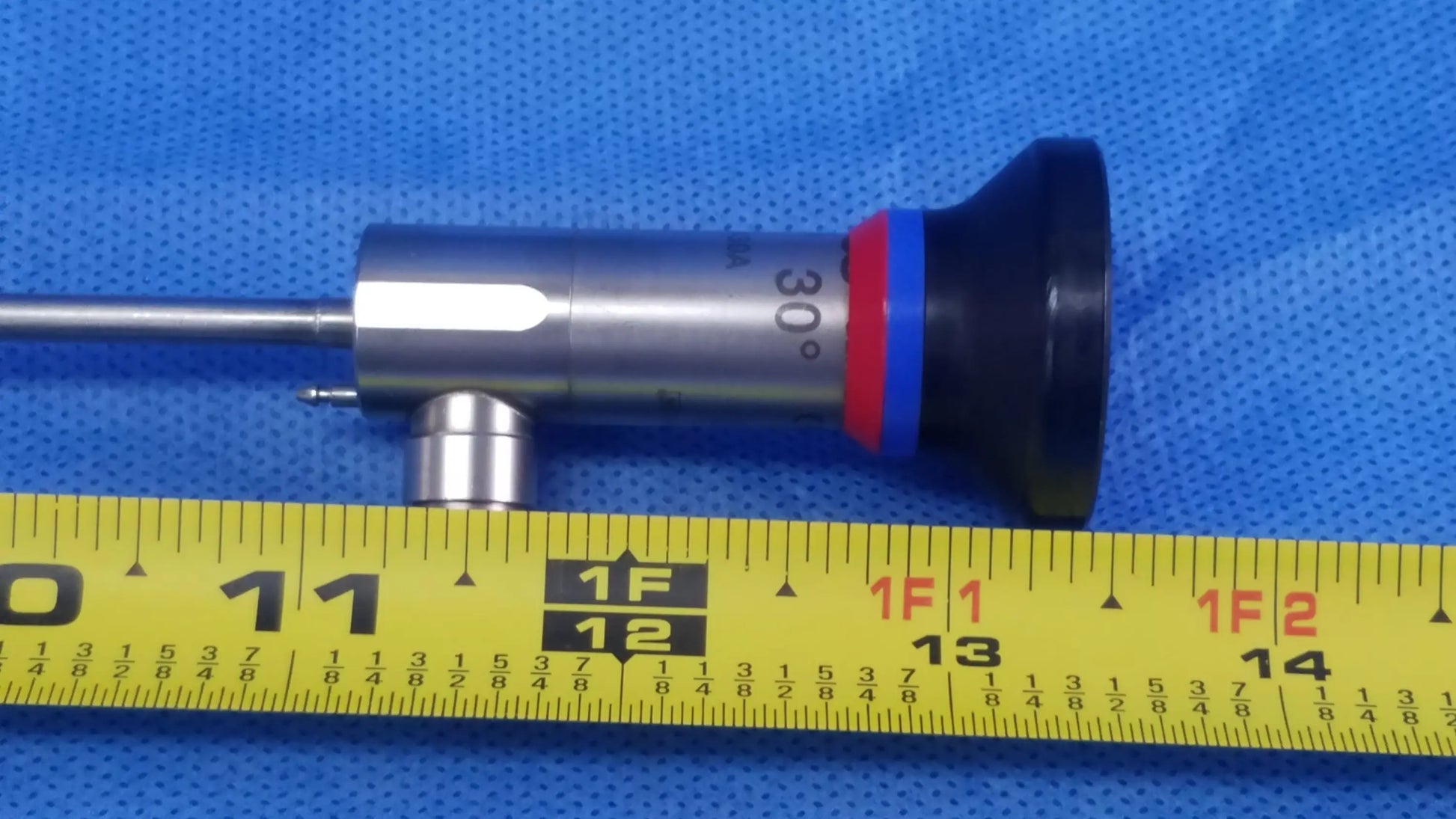 Silver olympus oes elite wa2t430a hd rigid telescope with 30 degree black red blue ringed tip on yellow measuring tape