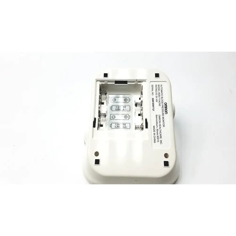 White plastic omron advanced blood pressure monitor hem-711ac showing battery compartment and labeled specifications