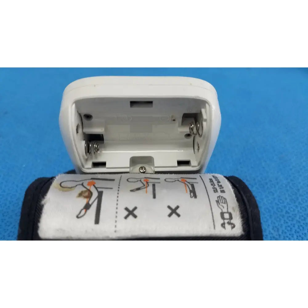 White plastic blood pressure cuff with black strap and instructions for omron automatic wrist blood pressure monitor