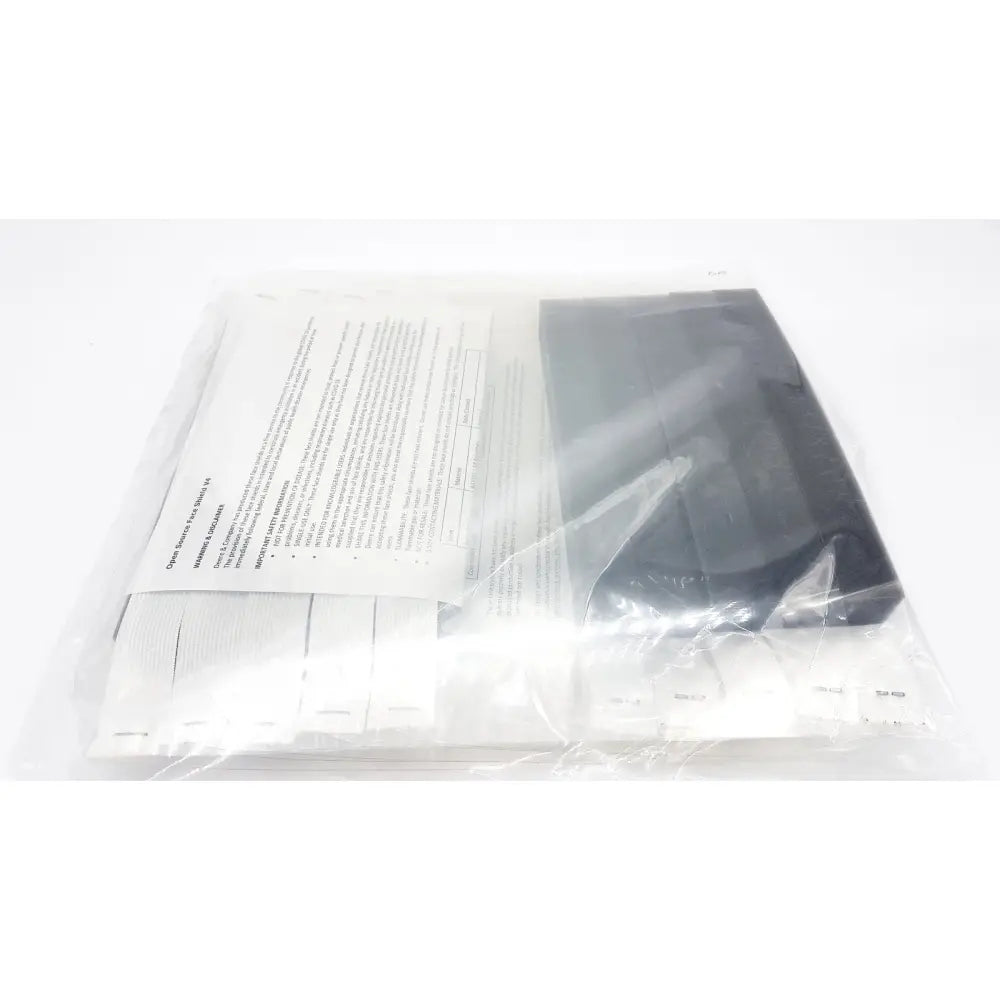 Black plastic case with white paper insert inside clear plastic bag featuring open source face shield v4 braw design