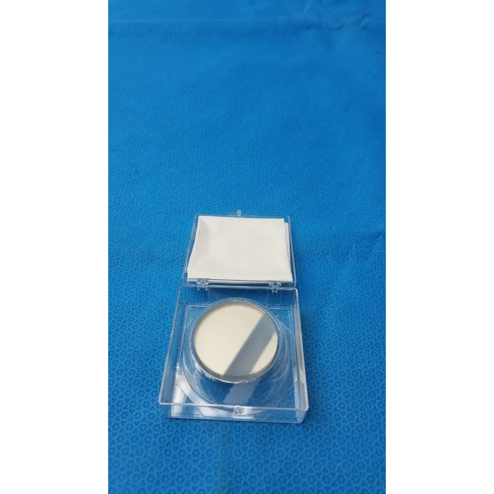 A round off-white optical container compact powder with metallic silver rim and clear plastic case by spawr industries