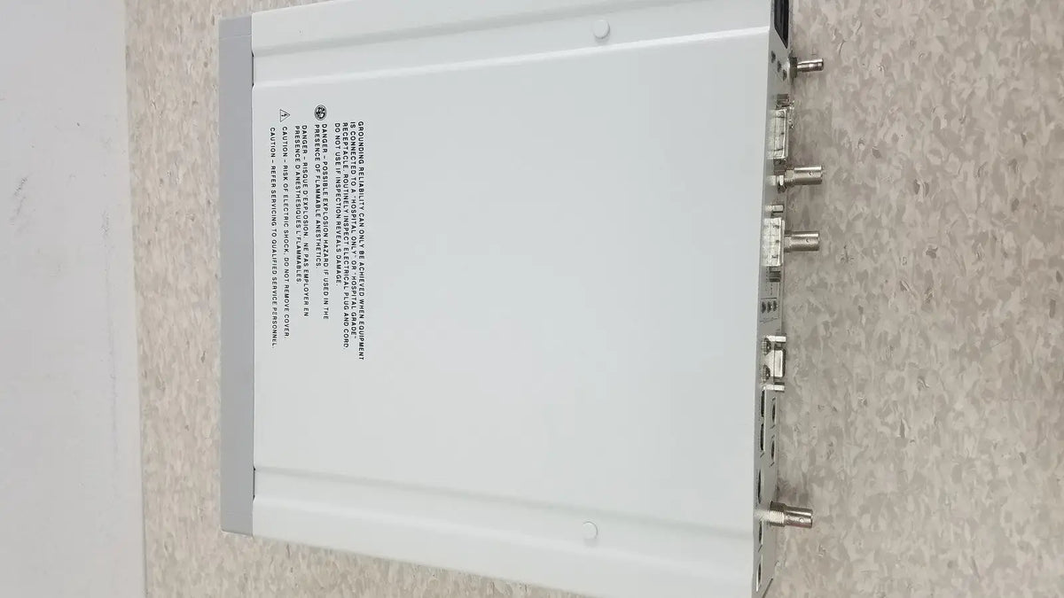 White rectangular optronics microcast 3ccd 1080p hd device with multiple metallic connectors on its back side