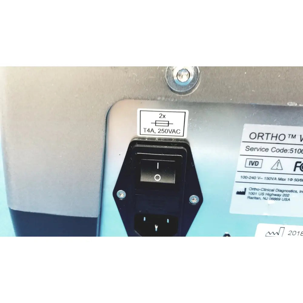 Black power input socket with toggle switch and electrical specifications on the back of ortho workstation ref 6904630 ortho clinical diagnostics