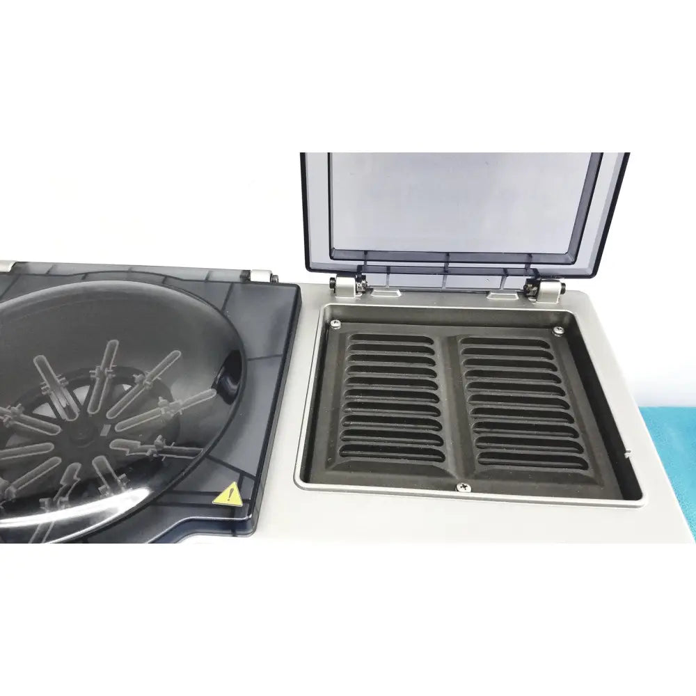 Black and silver laboratory centrifuge with transparent lid and open rotor chamber in ortho workstation ref by ortho clinical diagnostics