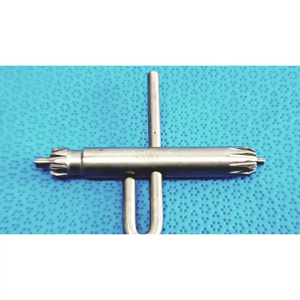 Silver metallic orthopedic drill chuck key with cross handle and two spikes branded seldinger waters compatible with 3.8mm and 3.2mm pin holes