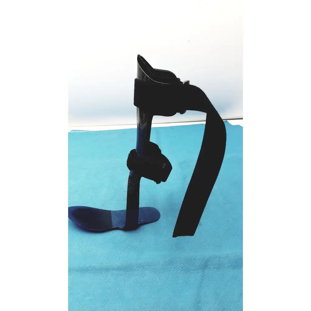 Black carbon fiber orthotic foot drop brace left foot with adjustable straps and contoured foot plate for support