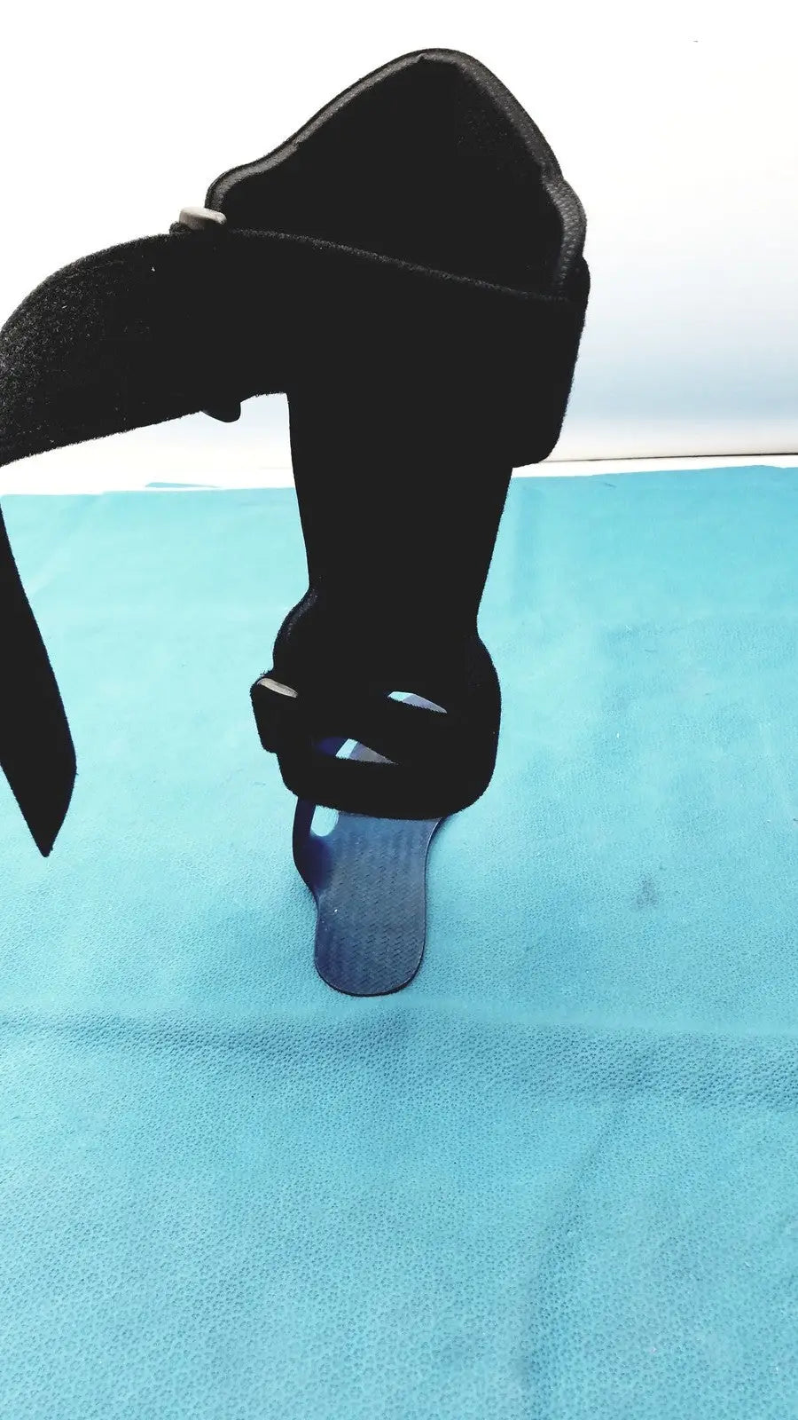 Black orthotic foot drop brace left foot with adjustable straps and blue plastic insert for ankle support