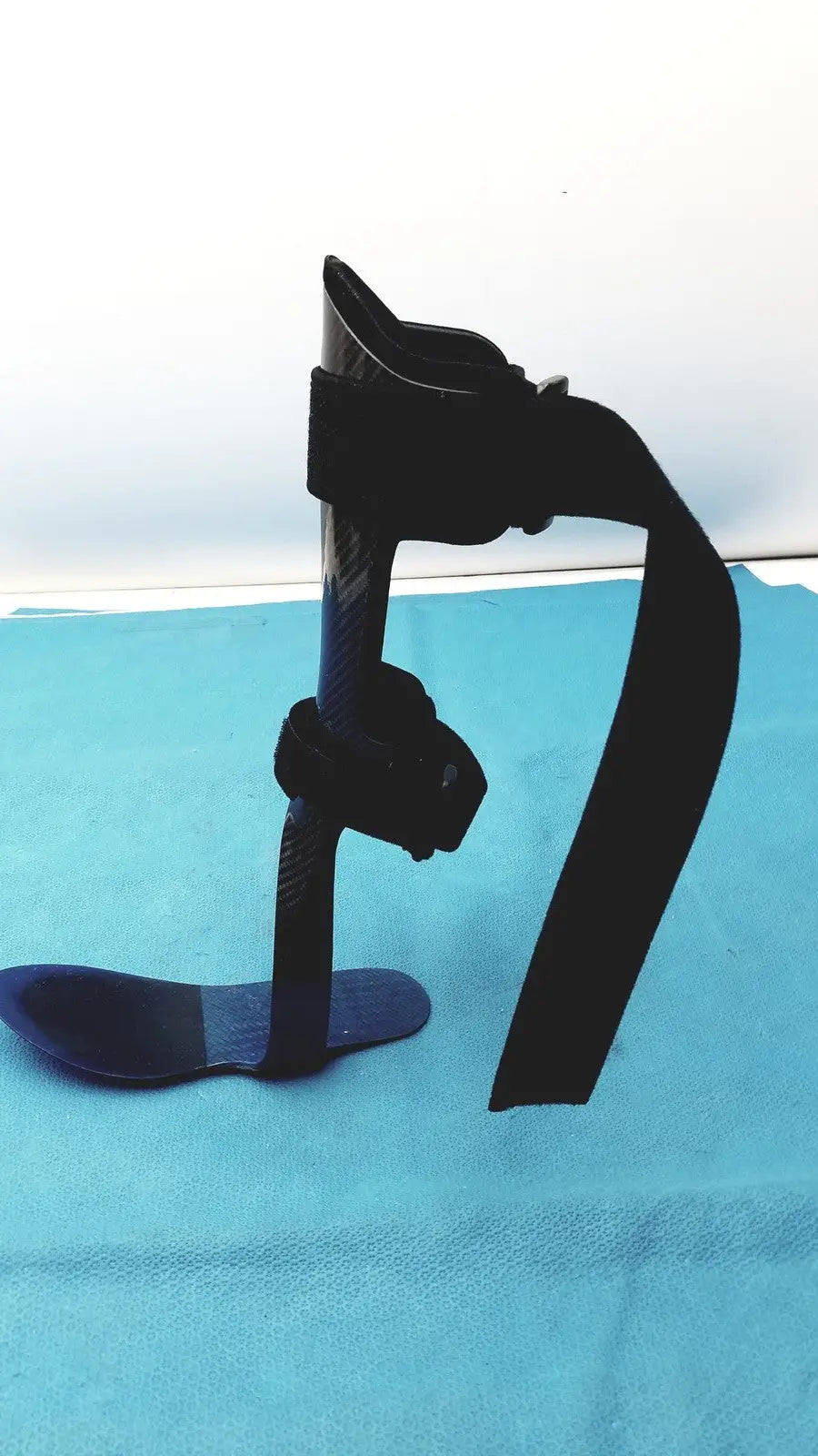 Black carbon fiber orthotic foot drop brace left foot with adjustable straps and contoured foot plate for support