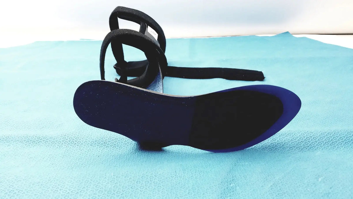 Black strappy orthotic foot drop brace left sandal with glossy blue insole and black sole for foot drop support