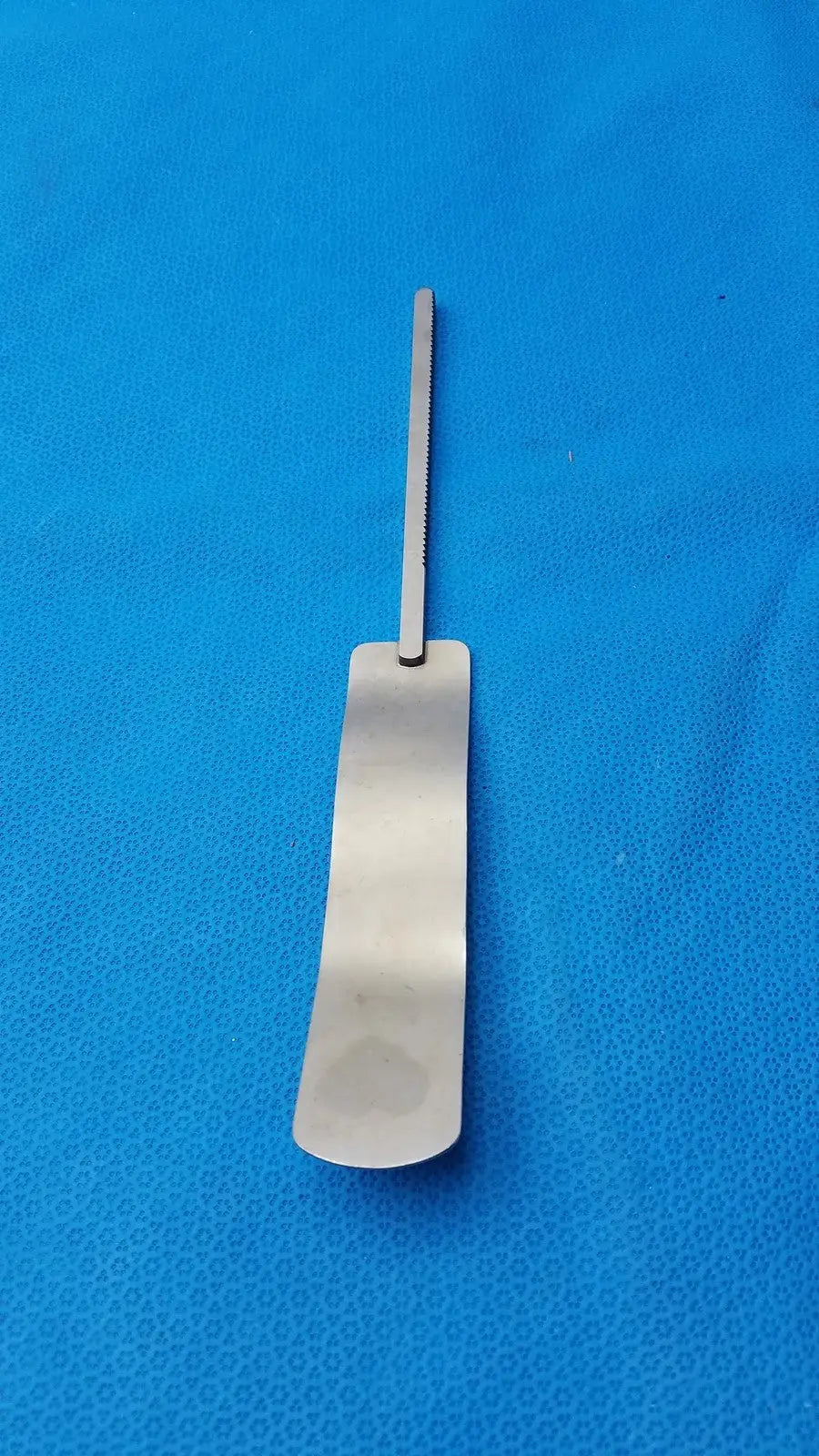 Osteotome stainless steel surgical instrument with a sleek rectangular handle and serrated edge in stainless steel
