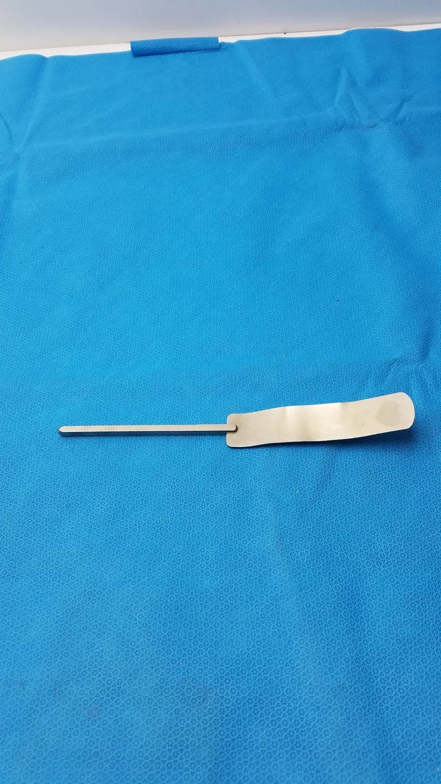 Osteotome stainless steel surgical instrument with a sleek metallic handle and flat rectangular blade for precision use