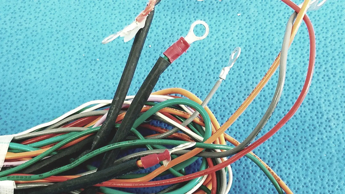 A tangle of multicolored connectors wire harness cable with exposed ends and red and silver ring terminals for P10 103