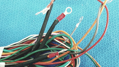 A tangle of multicolored connectors wire harness cable with exposed ends and red and silver ring terminals for P10 103