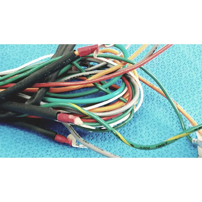 A tangle of multi-colored connectors wire harness cables with black green red white and yellow insulation and red connectors