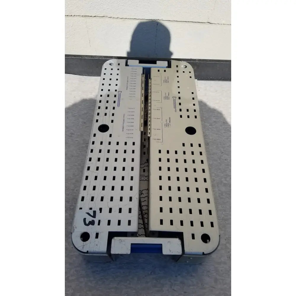 Silver metallic pelvic fragment surgical instrument tray with perforated surface and blue handle for reuse medical use