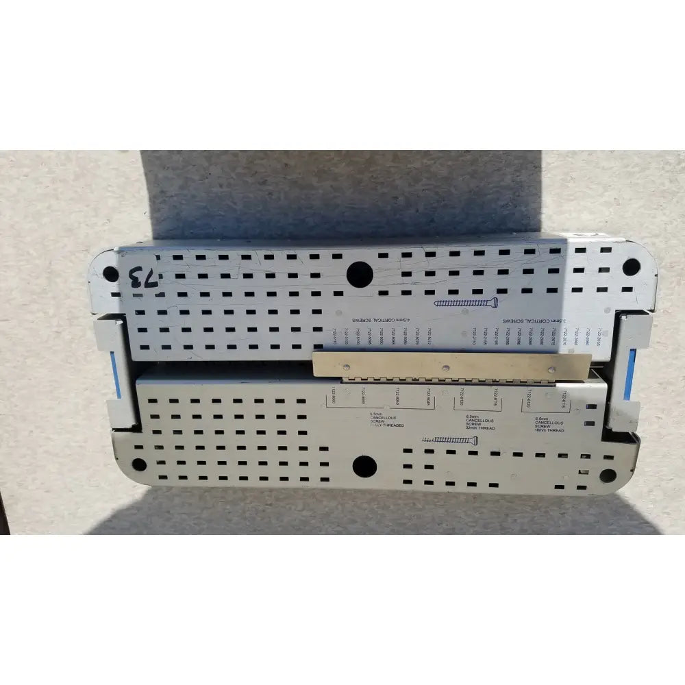 Silver metallic surgical instrument tray with perforated surface and labeled compartments for pelvic fragment reuse medical implants