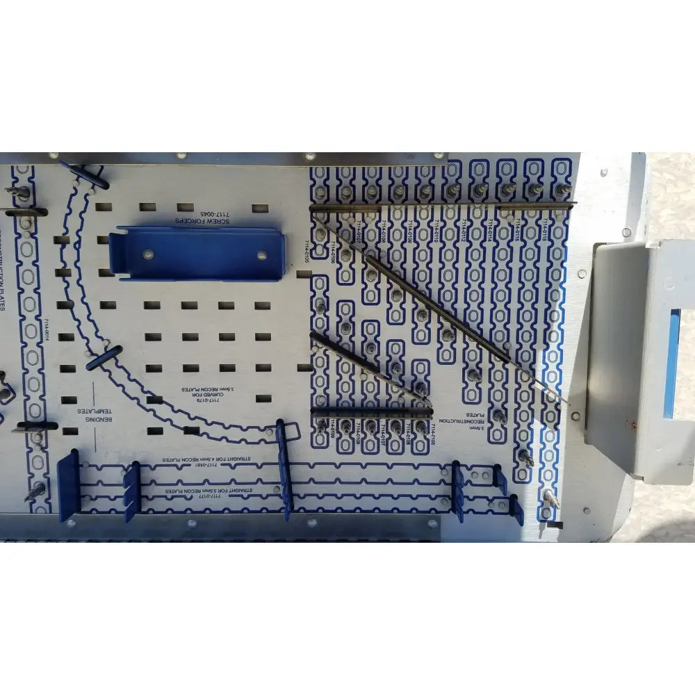 Blue plastic pelvic fragment component with metallic connectors mounted on white circuit board for reuse medical implants