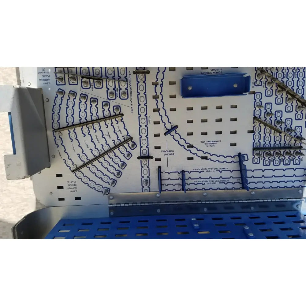 Blue and white pelvic fragment system implant plate with metal screws in a grid pattern for reuse medical applications