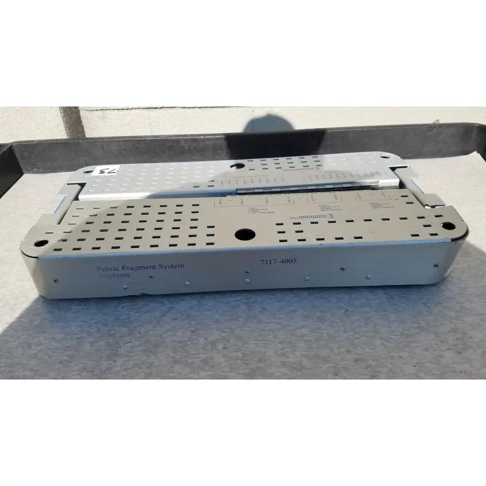 Silver metallic pelvic fragment system implant tray with perforated design and engraved labeling for reuse medical use