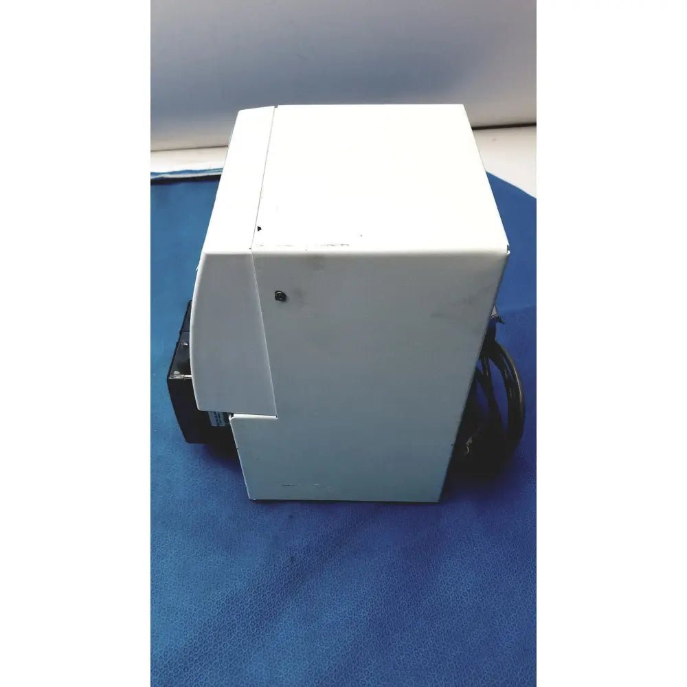 White plastic perkin elmer peri pump cjl8002 with coiled black power cord beside janus g3 workstation