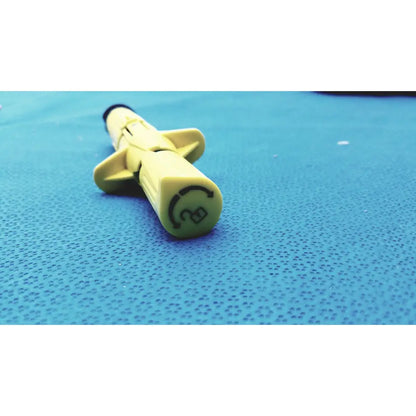 Yellow plastic syringe with black tip and circular logo on barrel from persys medical nio adult simulation kit