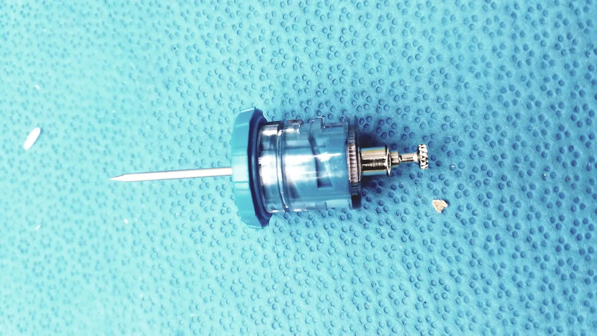 Blue plastic and metal faucet cartridge with silver needle-like protrusion for persys medical nio adult simulation kit