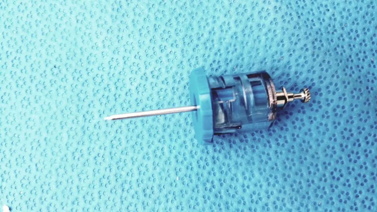 Blue plastic syringe with metallic needle and threaded cap from persys medical nio adult simulation kit