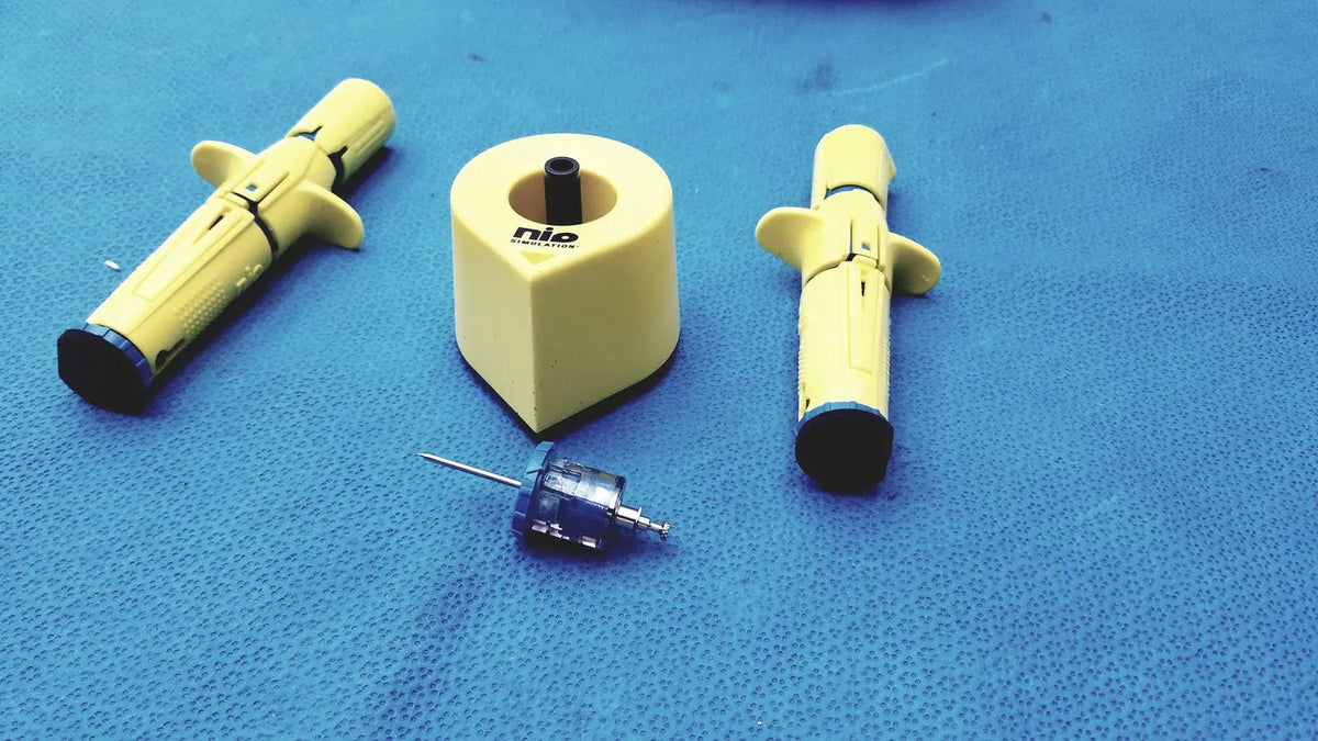 Yellow persys medical nio adult simulation syringe with black caps and side grips for medical nio adult training