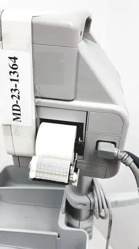 Gray plastic medical printer with white paper roll labeled md-23-1364 attached to philips intellivue mp5t patient monitor