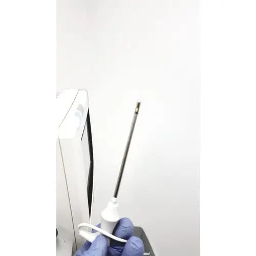 A white medical needle with black shaft and metallic tip held in gloved hands for philips intellivue mp5t patient use
