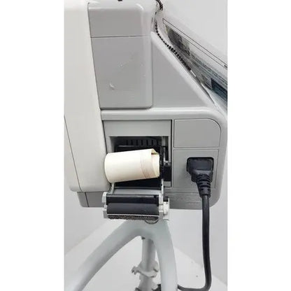White cylindrical paper roll loaded into gray industrial printer on philips intellivue mp5t patient monitor rolling stand