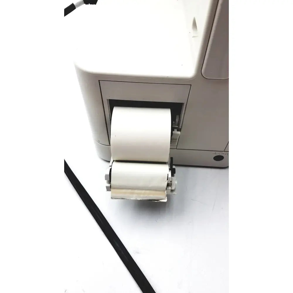 A white paper roll emerging from the printer output tray of a Philips IntelliVue MX400 patient monitor