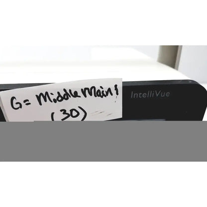 Black philips intellivue mx400 patient monitor with a handwritten note attached to the side of the device