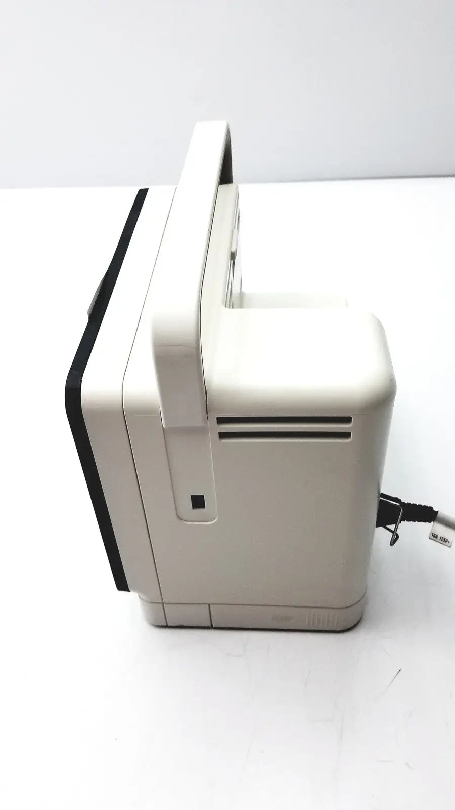 Beige plastic nintendo entertainment system console with black trim and handle shown with philips intellivue mx400 patient monitor