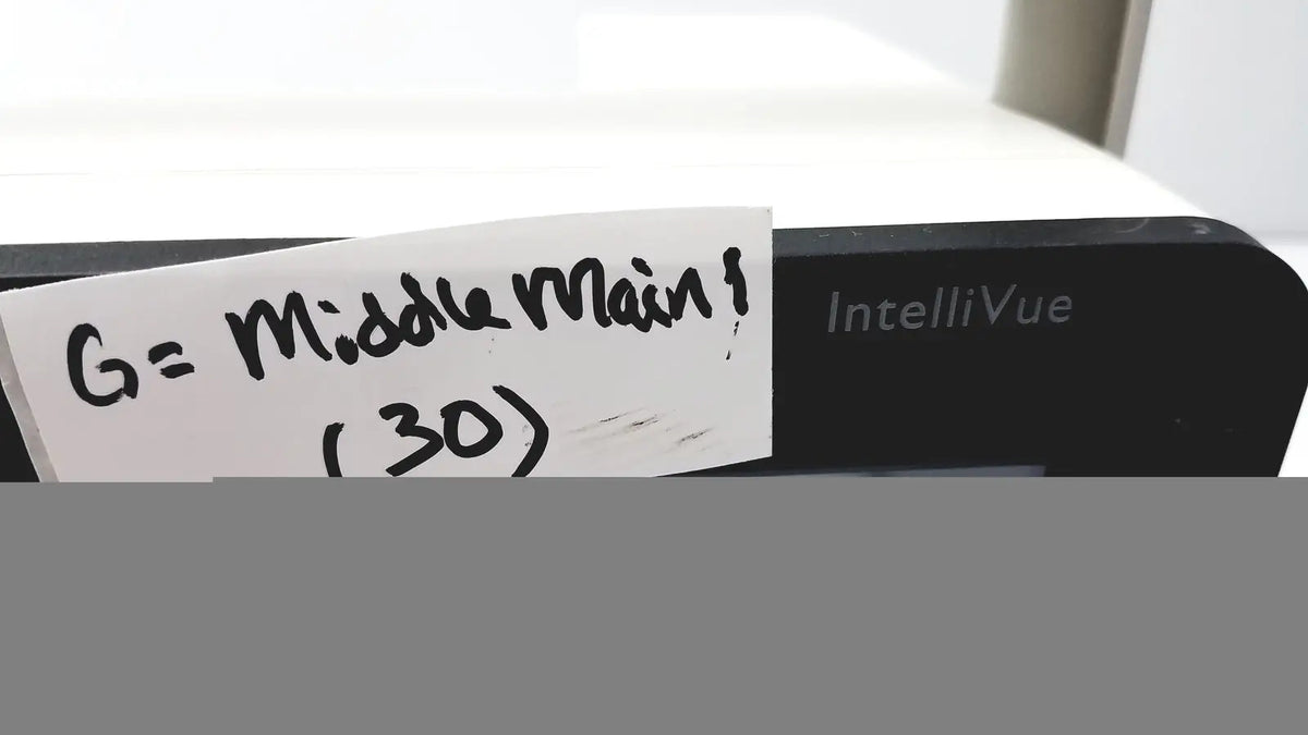 Black philips intellivue mx400 patient monitor with a handwritten note attached to the side of the device
