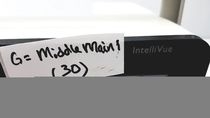 Black philips intellivue mx400 patient monitor with a handwritten note attached to the side of the device